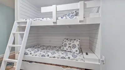 a room with two bunk beds with a pillow at Beach Dream Believer at Laketown Wharf #518 by Nautical Properties in Panama City Beach