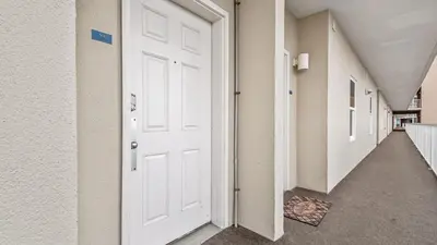 an empty corridor with a white door in a building at Beach Dream Believer at Laketown Wharf #518 by Nautical Properties in Panama City Beach