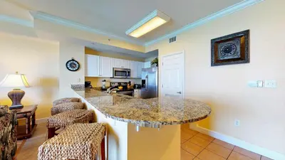 a kitchen with a large island in a living room at Tidewater 2204 in Panama City Beach