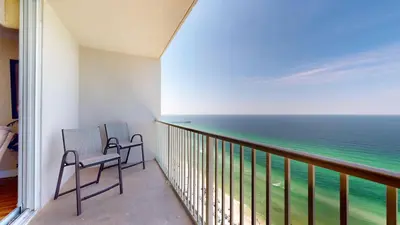two chairs on a balcony looking out at the ocean at Tidewater 2204 in Panama City Beach