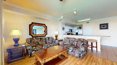 a living room with two couches and a table at Tidewater 2204 in Panama City Beach