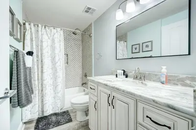 a bathroom with a sink and a toilet and a mirror at Celadon 209 in Panama City Beach
