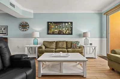 a living room with a couch and a table at Treasure Island #1505 in Panama City Beach