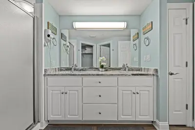a bathroom with a sink and a large mirror at Treasure Island #1505 in Panama City Beach