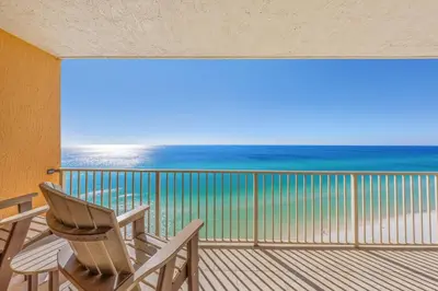 two chairs on a balcony with a view of the ocean at Treasure Island #1505 in Panama City Beach