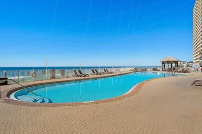 a swimming pool with the beach in the background at Treasure Island #1505 in Panama City Beach