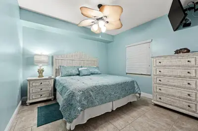 a bedroom with a bed and a ceiling fan at Treasure Island #0105 in Panama City Beach