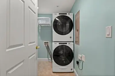 a laundry room with a washer and dryer next to a door at Treasure Island #0105 in Panama City Beach