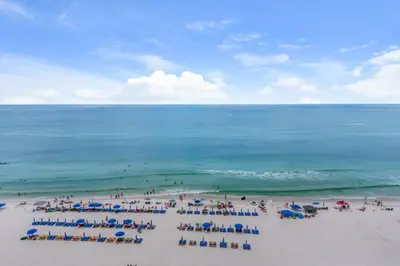 a group of people on a beach with chairs and umbrellas at Seychelles #1007 in Panama City Beach