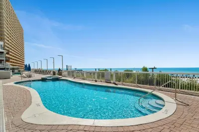 a swimming pool with blue water in front of the beach at Seychelles #1007 in Panama City Beach