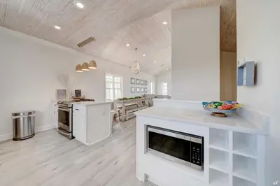 a large kitchen with white cabinets and a fireplace at Summer Towne Cottages #16 in Panama City Beach