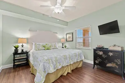 a bedroom with a bed and a ceiling fan at Treasure Island #0907 in Panama City Beach