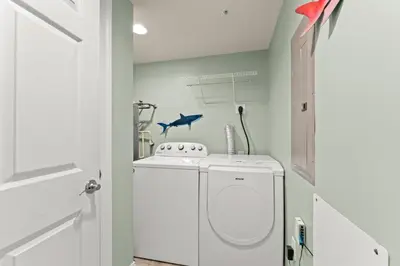 a white laundry room with a washer and dryer at Treasure Island #0907 in Panama City Beach