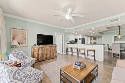 a living room with a couch and a tv and a table at Treasure Island #0907 in Panama City Beach