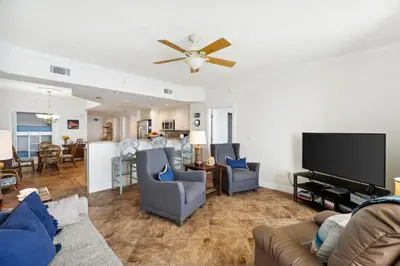 a living room with a couch and a flat screen tv at Treasure Island #2110 in Panama City Beach