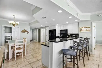 a kitchen and dining room with a table and chairs at Treasure Island #0206 in Panama City Beach