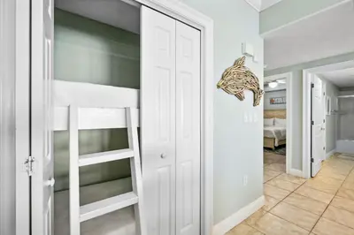 a room with a bunk bed and a ladder at Treasure Island #0206 in Panama City Beach