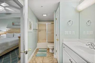 a bathroom with a bed and a sink and a toilet at Treasure Island #0206 in Panama City Beach
