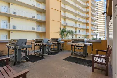 a patio with tables and bbq equipment in a building at Treasure Island #0206 in Panama City Beach