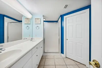 a bathroom with a white sink and a white door at Treasure Island #1608 in Panama City Beach