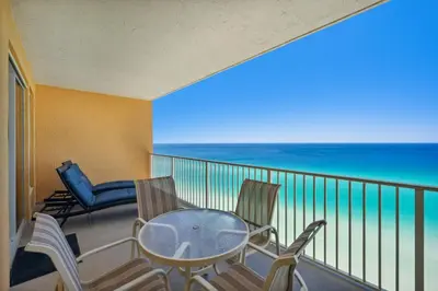 a balcony with a table and chairs and the ocean at Treasure Island #1608 in Panama City Beach