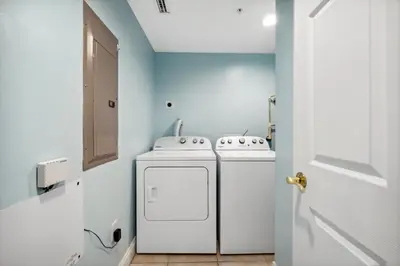 a laundry room with two washes and a dryer at Treasure Island #1608 in Panama City Beach