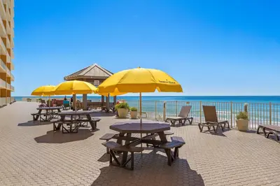 a group of tables and chairs with umbrellas on the beach at Treasure Island #1110 in Panama City Beach