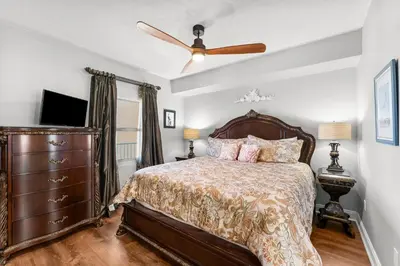 a bedroom with a bed and a ceiling fan at Treasure Island #1110 in Panama City Beach