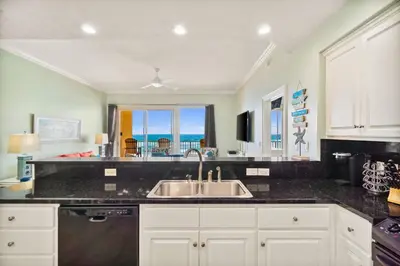 a kitchen with a sink and a view of the ocean at Treasure Island #0303 in Panama City Beach