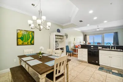 a kitchen and dining room with a dining table and a dining room at Treasure Island #0303 in Panama City Beach
