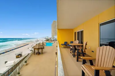 a balcony with tables and chairs and the beach at Treasure Island #0303 in Panama City Beach