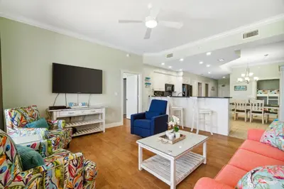 a living room with two couches and a tv at Treasure Island #0303 in Panama City Beach