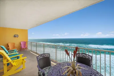 a balcony with a table and chairs and the ocean at Treasure Island #1005 in Panama City Beach