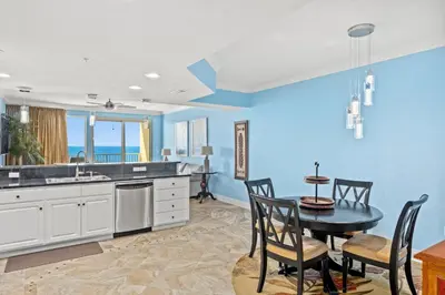 a kitchen with blue walls and a table and chairs at Treasure Island #1506 in Panama City Beach