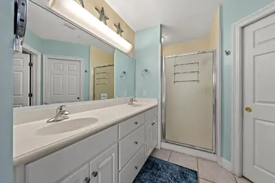 a bathroom with a sink and a shower and a mirror at Treasure Island #0310 in Panama City Beach