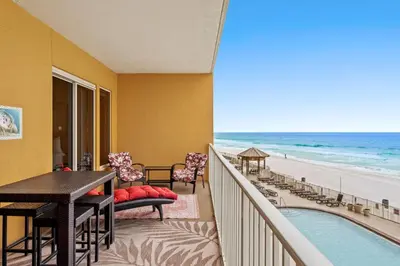 a balcony with a table and chairs and the beach at Treasure Island #0310 in Panama City Beach