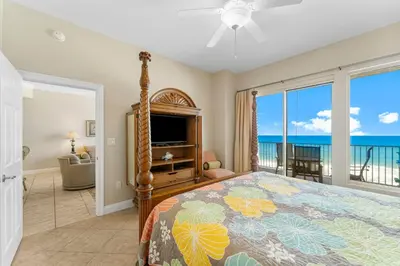 a bedroom with a bed and a view of the ocean at Treasure Island #0507 in Panama City Beach