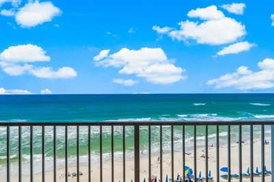 a view of a beach with chairs and the ocean at Treasure Island #0507 in Panama City Beach