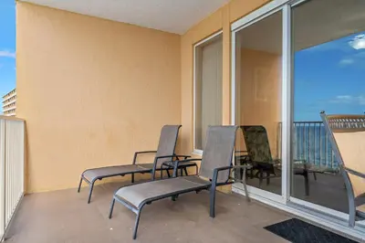 a balcony with three chairs and a table with a view at Treasure Island #1807 in Panama City Beach