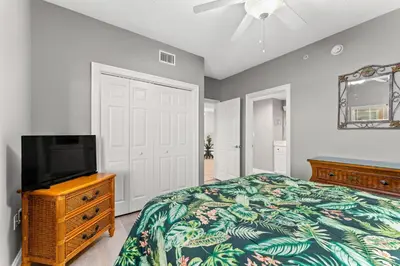 a bedroom with a bed and a flat screen tv at Treasure Island #1807 in Panama City Beach