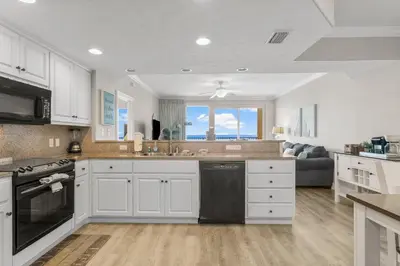 a kitchen with white cabinets and a large window at Treasure Island #2306 in Panama City Beach
