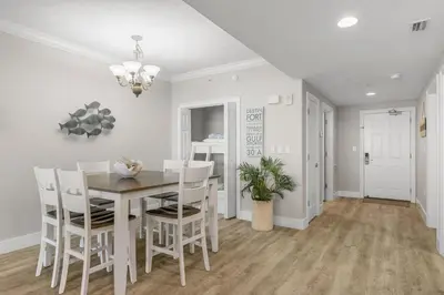 a dining room with white walls and a table and chairs at Treasure Island #2306 in Panama City Beach