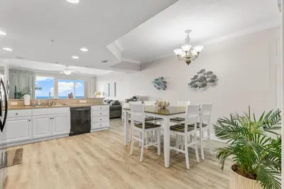 a kitchen and dining room with a table and chairs at Treasure Island #2306 in Panama City Beach