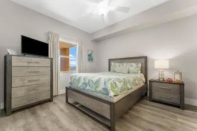 a bedroom with a bed and a flat screen tv at Treasure Island #2306 in Panama City Beach