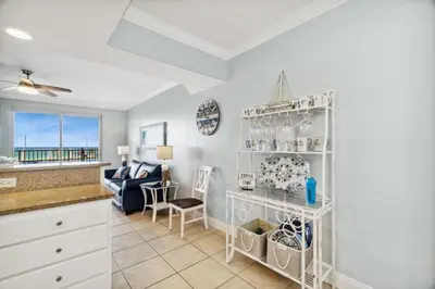 a kitchen and living room with a view of the ocean at Treasure Island #0110 in Panama City Beach
