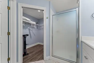 a walk in closet with a glass door leading to a walk in shower at Treasure Island #0409 in Panama City Beach