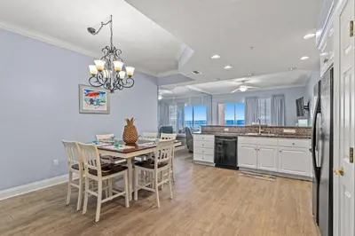 a kitchen and dining room with a table and chairs at Treasure Island #0409 in Panama City Beach