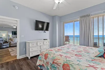 a bedroom with a bed and a view of the ocean at Treasure Island #0409 in Panama City Beach