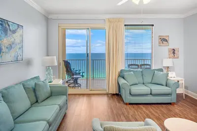 a living room with a couch and chairs and a balcony at Treasure Island #2109 in Panama City Beach