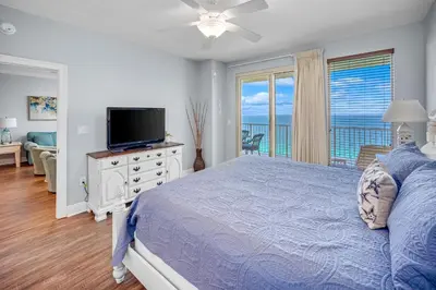 a bedroom with a blue bed and a television at Treasure Island #2109 in Panama City Beach